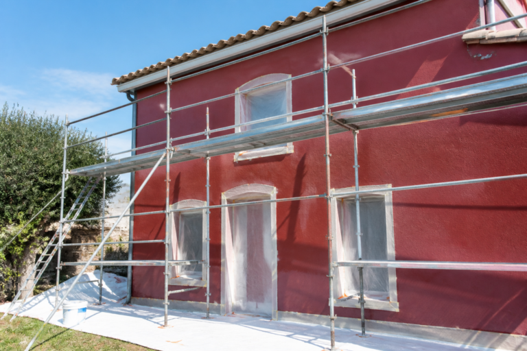 Façade maison en Gironde peinte en couleur bordeaux lors d'un chantier de rénovation avec protections