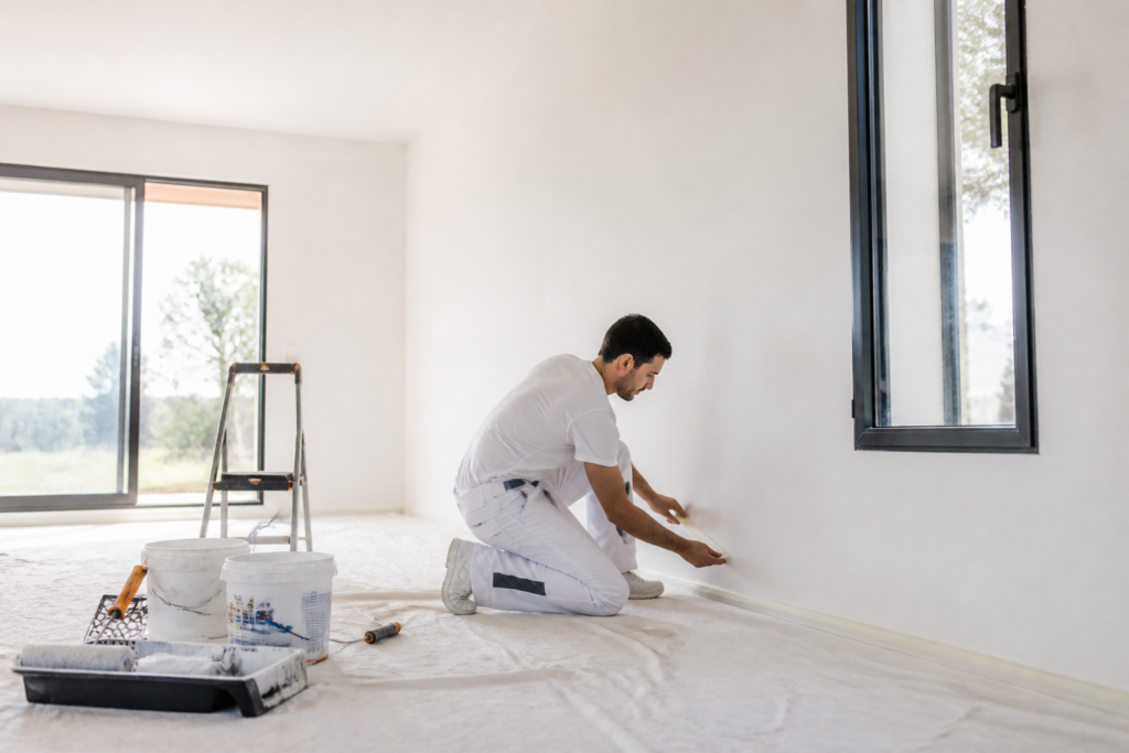 Artisan peintre préparant un mur intérieur dans une maison neuve en Gironde