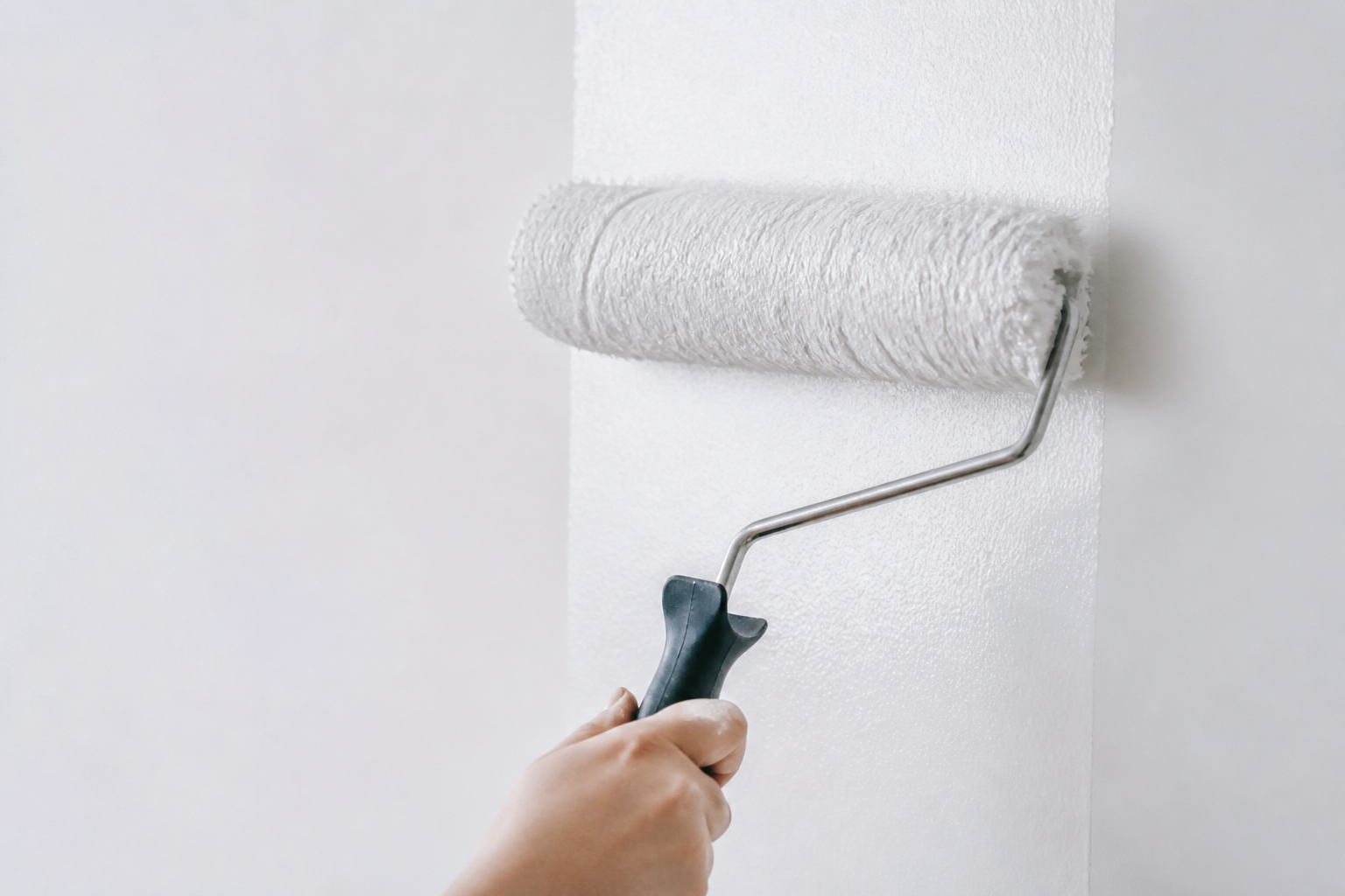 Rouleau appliquant peinture blanche sur mur lisse sans trace